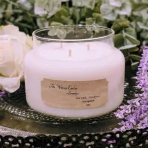 White candle surrounded by flowers on table.