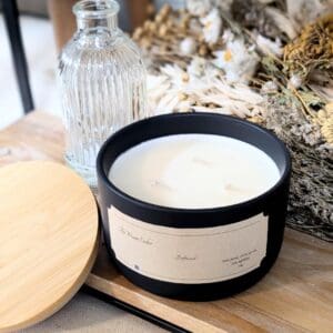 Black candle jar with dried flowers and bottle.